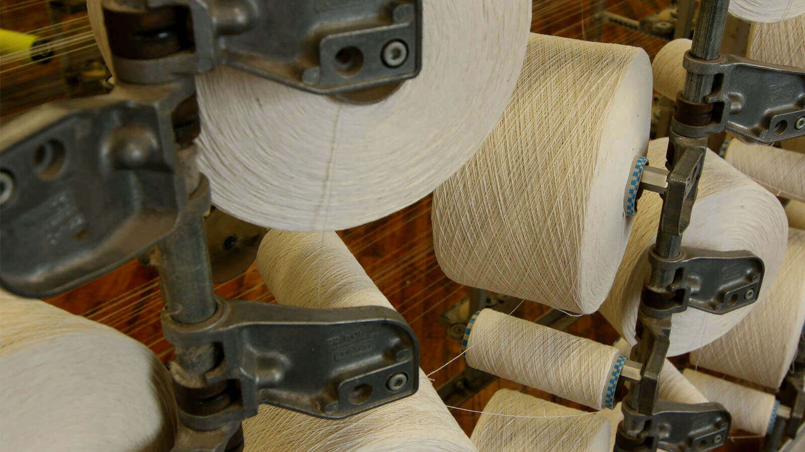 Close-up of several spools of tan thread ready to be used inside the Wayne Mills facility