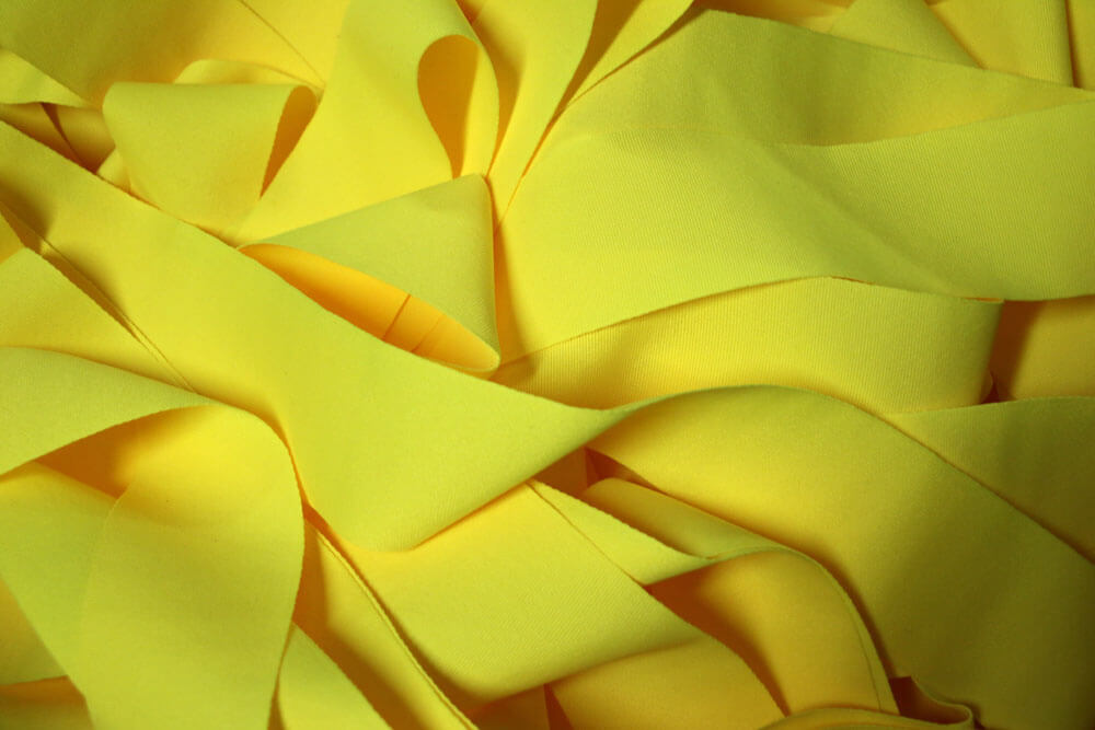 Long pieces of bright yellow fabric tangled together