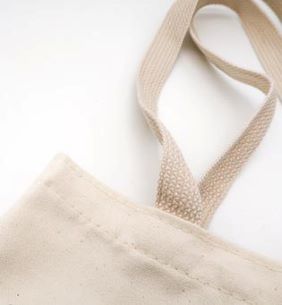 Close-up of a cream canvas bag's edge and strap.