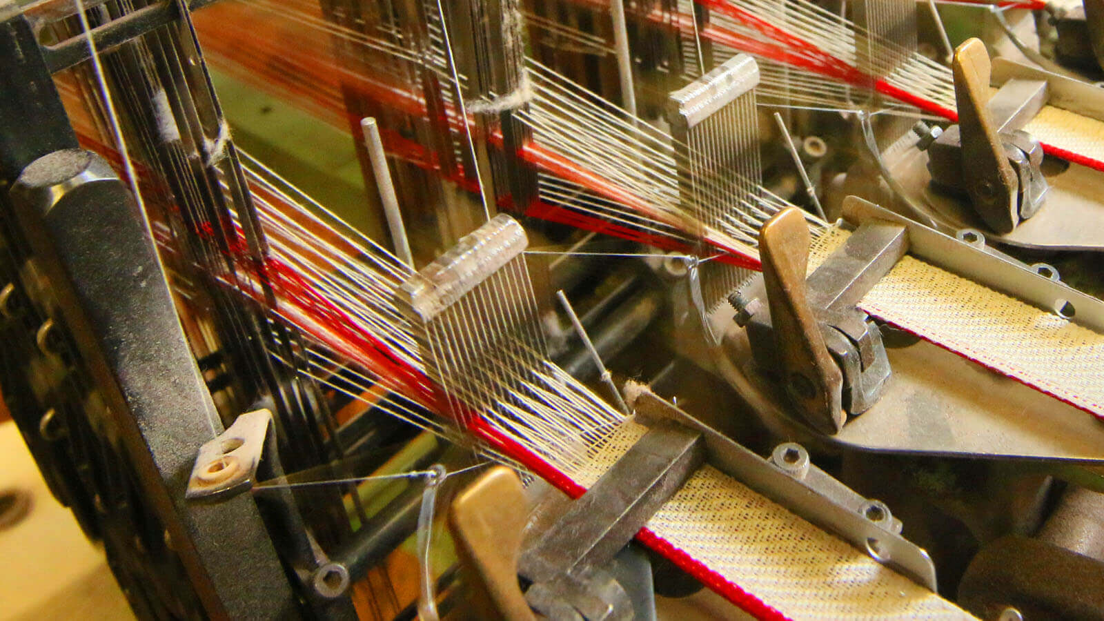 Close-up of fabric being woven by an industrial machine in a factory