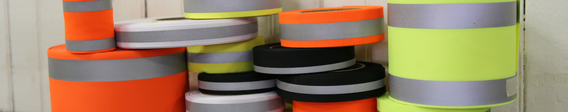 Spools of multi-colored reflective laminated fabric stacked on top of each other