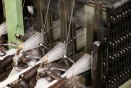 White fabric being processed by a machine in a textile facility